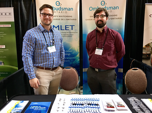 Two members of staff tending the OEMC booth