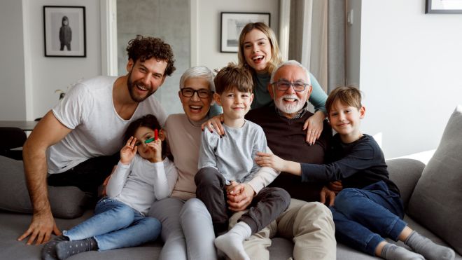A multi-generational family sitting on a couch