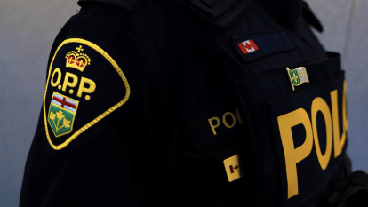 Franco-Ontarian flag on the uniform of an Ontario Provincial Police officer, signifying the officer speaks French.
