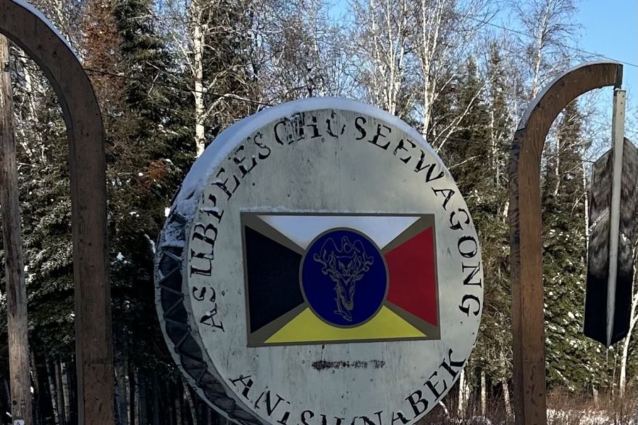 Sign depicting a medicine wheel and "Asubpeeschoseewagong Netum Anishinabek" written around it.