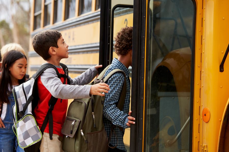 Des enfants montent dans un bus scolaire Des enfants montent dans un bus scolaire