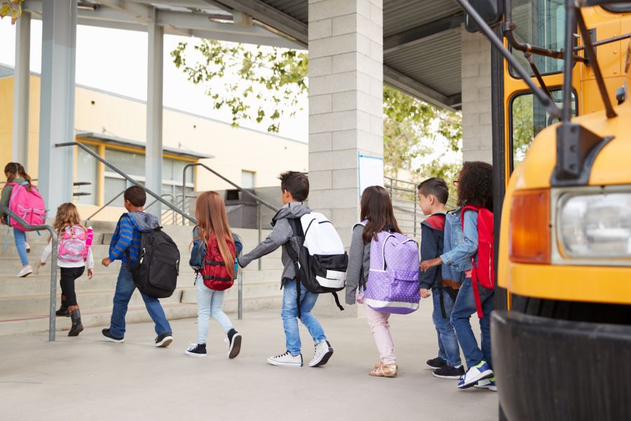 Groupe d'enfants descendant d'un autobus scolaire