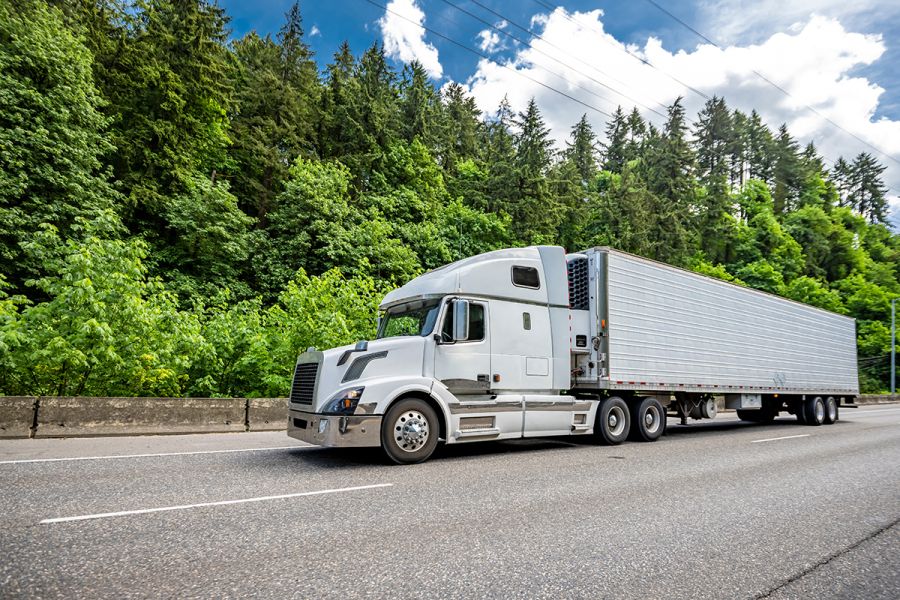 White transport truck driving on highway