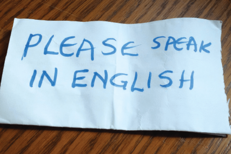 Piece of paper with "Please speak in English" written on it