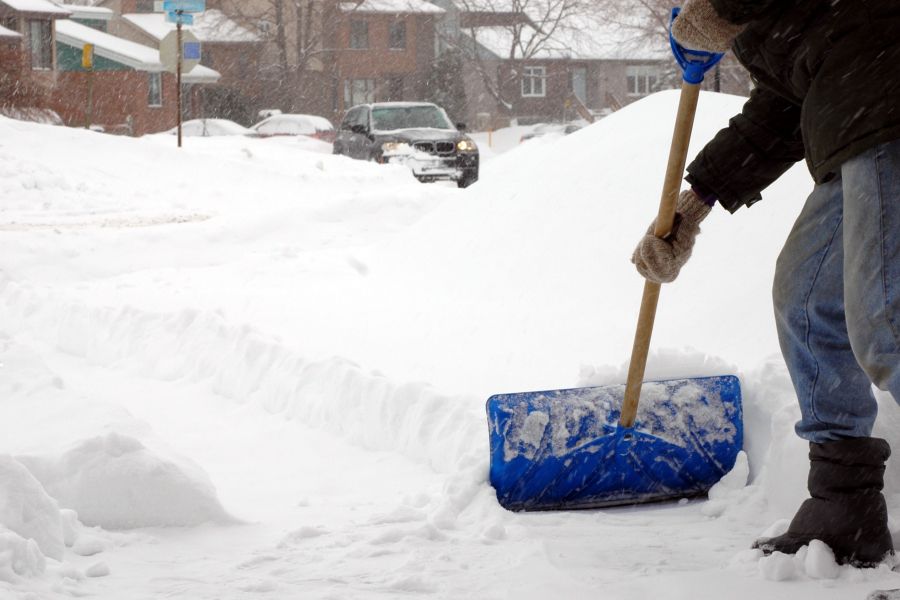 Person shovelling snow on a residential street