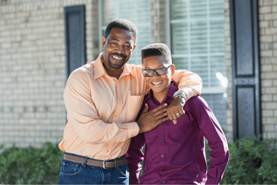 An adult with arms around a teenager.