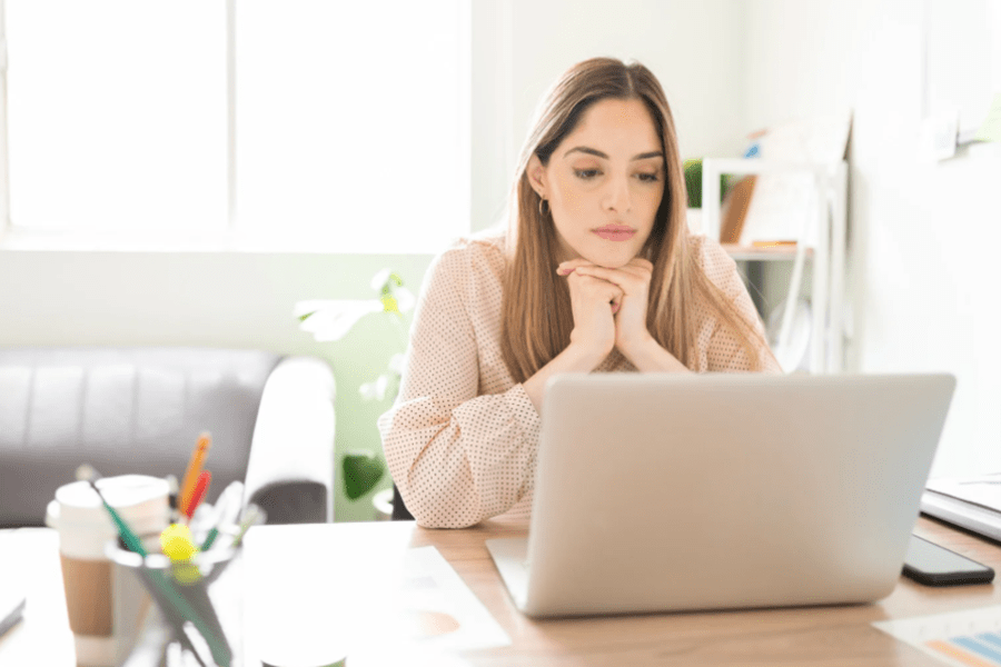  Femme à son bureau regardant un ordinateur