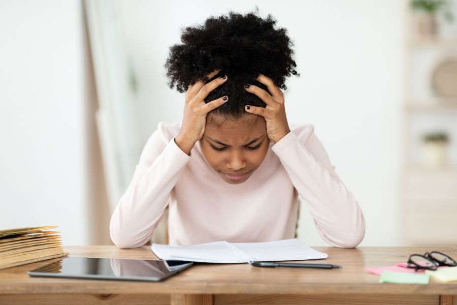 Woman sitting at desk staring at bill