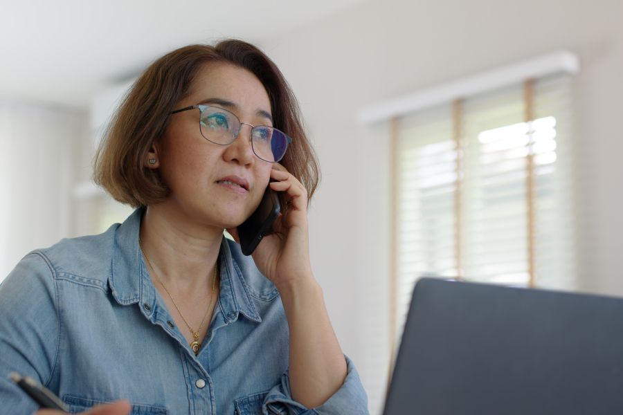 Woman with open laptop speaking on phone